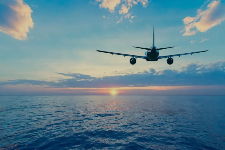 👉 Airplane flying above ocean during sunset | International air freight services UAE