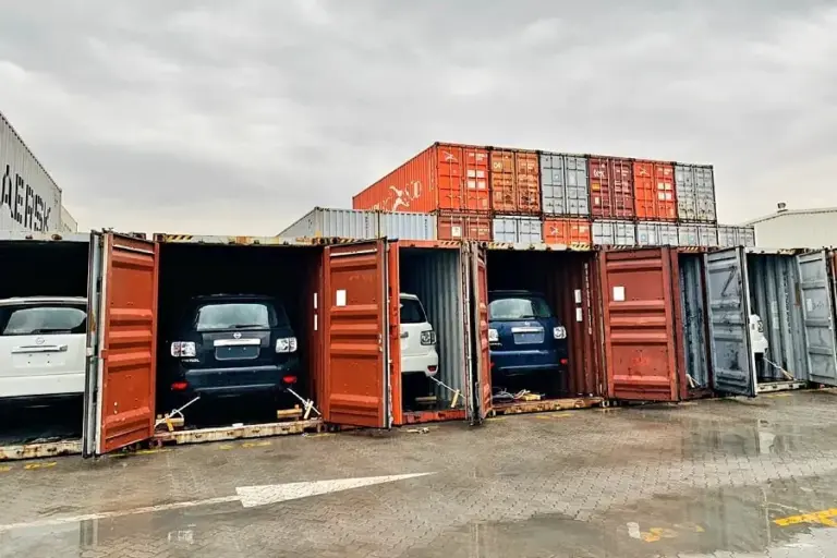 Container loading with vehicles for export from Dubai to Africa, showing secure international car shipping and logistics services by Tawam Al Shahin Transport.